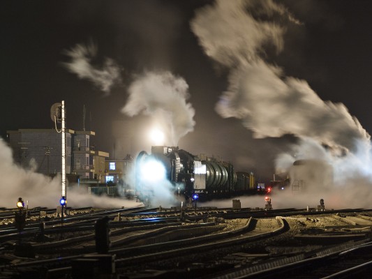 A single QJ steam locomotive leads an eastbound Jitong Railway freight train out of Daban, Inner Mongolia, China, on a November night in 2005.