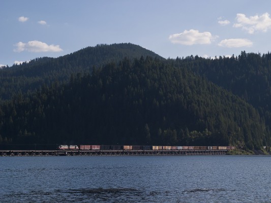 The St. Maries River Railroad's inbound Plummer Turn crosses the low trestle over Benewah Lake on the former Milwaukee Road main line just west of St. Maries, Idaho, as evening shadows creep across the mountains in July 2004.