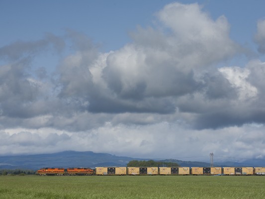 Portland and Western's American Turn local freight train heads south up the Willamette Valley as clouds roll above the Coast Range mountains on May 11, 2009.
