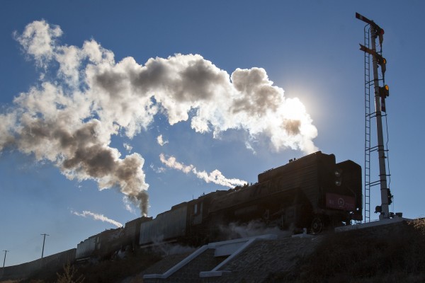 Two QJ steam locomotives pass a semaphore signal near Chagganhada, Inner Mongolia, China, on October 2, 2005.