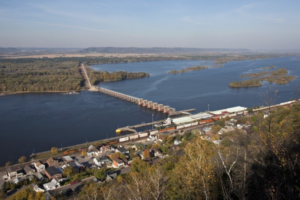 BNSF Railway eastbound intermodal train in Alma, Wisconsin, as an upriver tow navigates Lock 4 on the Mississippi River on October 9, 2011.