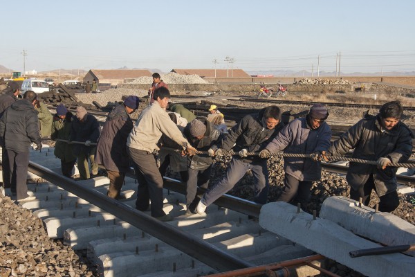 Jitong Railway workers lay rail for a new yard track in Daban, Inner Mongolia, China, in November 2005.