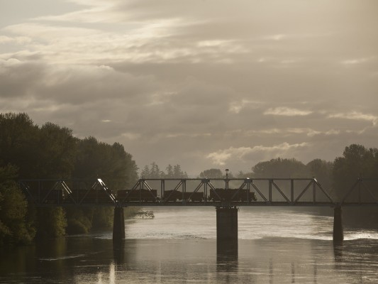 At the end of its all-night run to Toledo and back, Portland and Western's Toledo Hauler crosses the Willamette River into Albany, Oregon, just after sunrise on May 7, 2009.