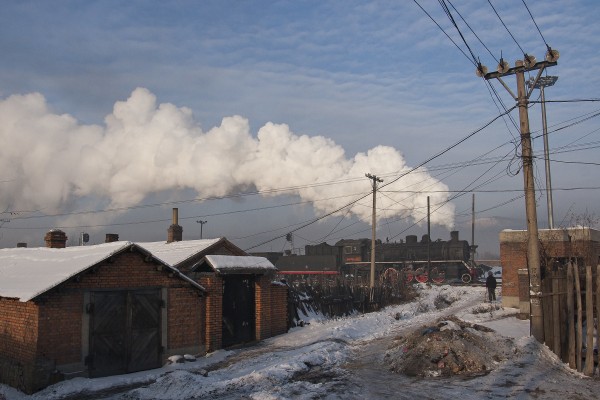 Jixi Coal Railway train passing an alley in Jixi on its way to a mine.