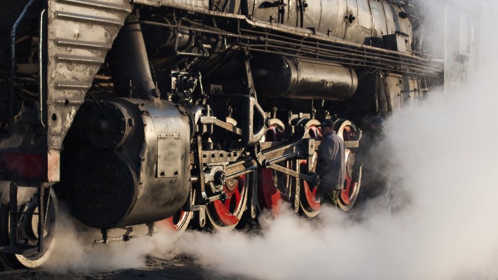 Steam engulfs the running gear of a Jitong Railway QJ steam locomotive in October 2005.