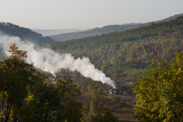 On the narrow gauge (30 in.) Huanan Forestry Railway, two 0-8-0 C2-class steam locomotives push and pull an eight-car coal train up the two percent grade out of Lixin on a beautiful autumn morning. The Huanan Railway was located in Heilongjiang in far northeastern China. It closed in 2011 when a new road opened.