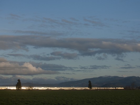Amtrak's <i>Coast Starlight</i> passenger train glints in the setting sun as it rolls south up the Willamette Valley on February 16, 2010.