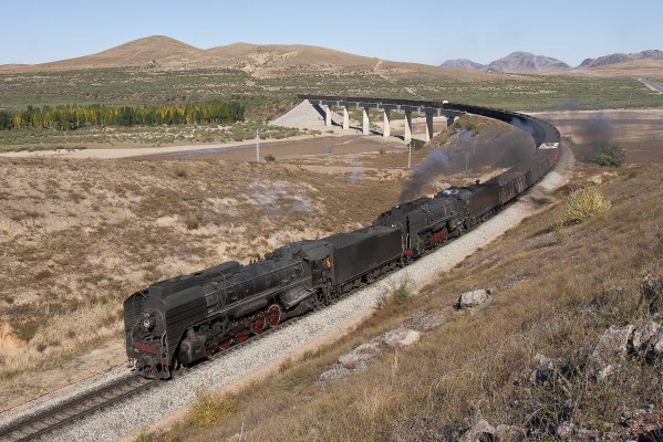 Two QJ steam locomotives lead a westbound JItong Railway freight train over the big bridge near Chagganhada on October 2, 2005.