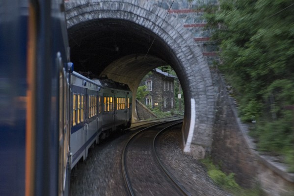 The opened window of the day’s last southbound local passenger train offers this view a typical stone-faced tunnel portal and stone lineman’s house on the the Semmering Railway.