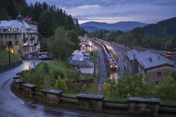 At twilight of a stormy day, a southbound freight train has nearly finished its climb up from Vienna and is about to enter the 4,695-foot-long Semmering Tunnel at the resort town of Semmering.