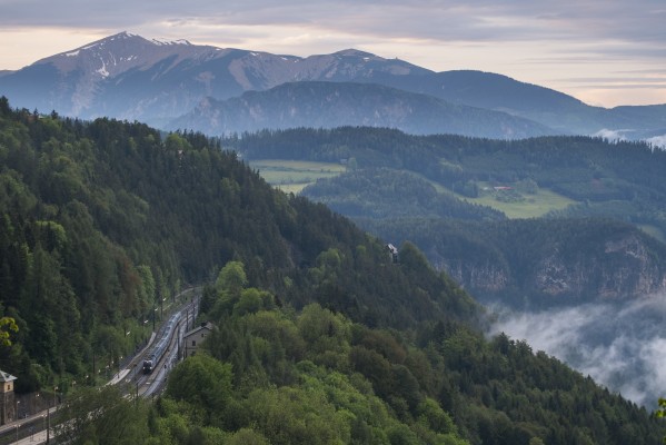 Mist hangs in the valleys after an evening thunderstorm at Semmering, as a southbound Railjet nears the summit tunnel. In the background is the 6,811-foot Schneeberg, the highest mountain in Lower Austria.