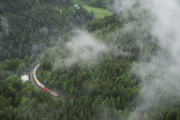 A northbound empty container train rolls downgrade past a lineman’s house toward Kalte Rinne Viaduct.