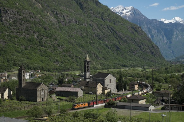 Four electric locomotives lead a container train north through Giornico, Switzerland, on the southern approach of Gotthard Pass.