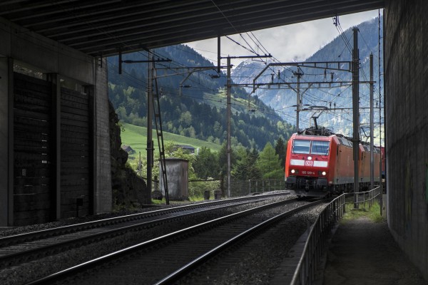 Hiking trails follow the railway over the entire northern slope of Gotthard Pass. Here the tracks and trail share a concrete gallery that protects the line from snow and landslides. Two Deustche Bahn class 185 electrics enter with a downhill freight.