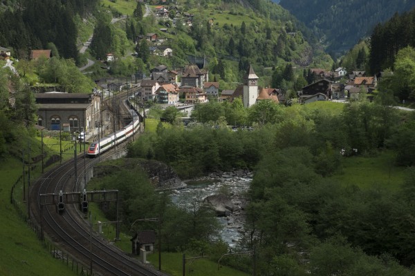 The late morning sun finds a break in the clouds at Gurtnellen as an ICN passenger train heads north along the River Reuss.