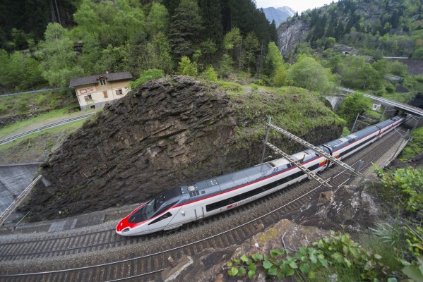 Taking in all of the railway infrastructure in the tight confines of the Piottino Gorge requires a very wide lens. This fisheye perspective includes a deep cut, lineman's house, bridge over the Ticino River, lower portal of the Freggio spiral tunnel, and upper level of track beyond it in the background. An ICN passenger train south descends the grade.