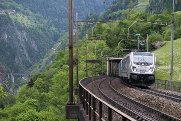 Railpool electrics of Bombardier's TRAXX series lead a container train south over the Intschireuss Bridge, highest on the Gotthard route at 253 feet. The Chärstelenbach Bridge at Amsteg is visible in the background at left.