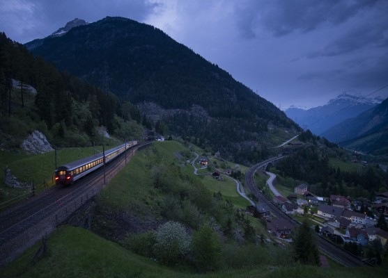As twilight envelopes the mountains at Wassen, the lights of InterRegio train north glow warmly.