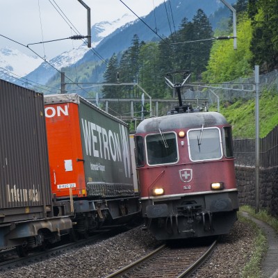 Container trains pass just above the Intschireuss Bridge; leading the downhill train is Re 620 no. 111632, a four-decade veteran of Gotthard freight service.