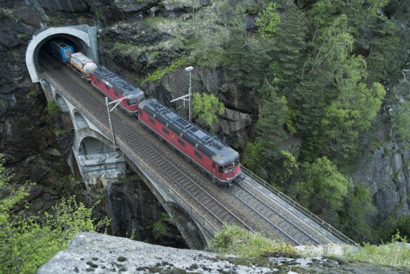 Swiss Federal Railways electric locomotives haul a freight train south across the Upper Meienreuss Bridge at Wassen. A 10,700-horsepower, six-axle Re 620 leads a 6,300-horsepower, four-axle Re 420.