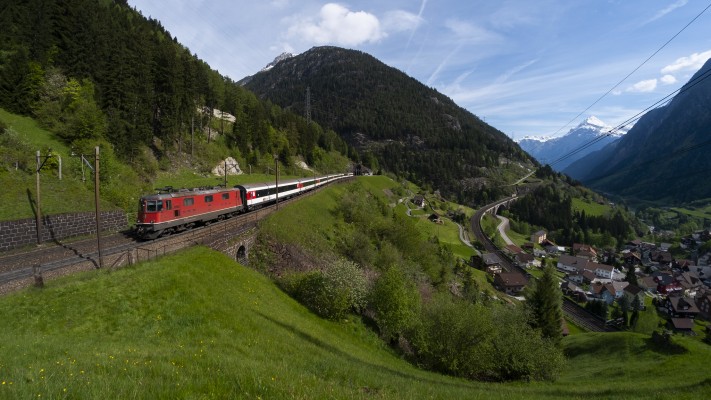 An InterRegio passenger train rolls south on the upper level of track at Wassen, Switzerland, on a beautiful spring morning.