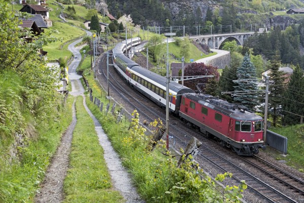 InterRegio train 2314 from Locarno to Basel descends through the middle level of looping track at Wassen at 7:17 a.m., still more than an hour before the sun would reach the deep valley.