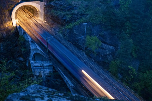 After assisiting a container train up the grade to Goeschenen, a single locomotive streaks across the Upper Meienreuss bridge in Wassen on its way back to Erstfeld to help another train.