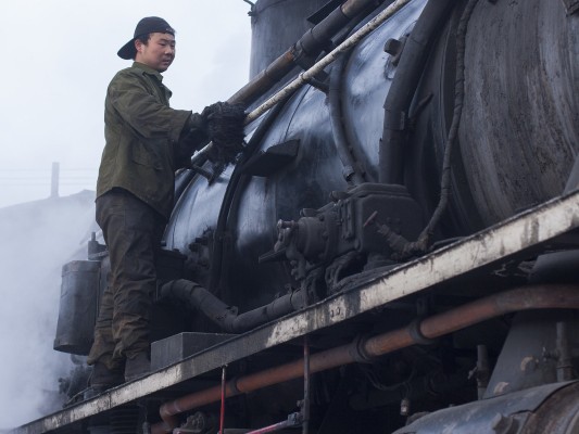 A worker tends to an SY-class locomotive on the Jixi Coal Railway.