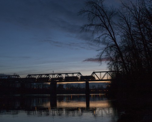 Portland and Western's Toledo Hauler crosses the Willamette River as it leaves Albany, Oregon, at sunset on February 16, 2009, for an all-night run to Toledo and back.