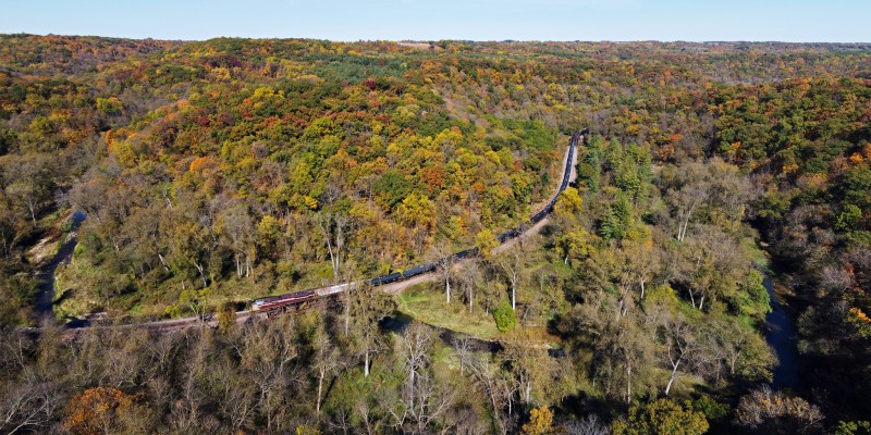 The leaves along Bloody Run are beginning to show their autumn colors as Canadian Pacific train 681 climbs the grade out of the Mississippi River Valley on October 8, 2020. Heritage locomotive 7017 is running solo on the empty unit train bound for the ethanol plant at Charles City, Iowa.
