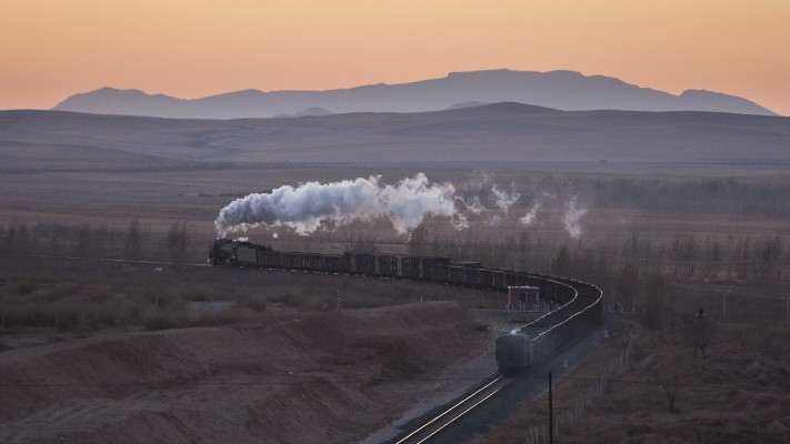 At twilight on a November day in 2005, a Jitong Railway freight train heads west near Chagganhada, Inner Mongolia, China.