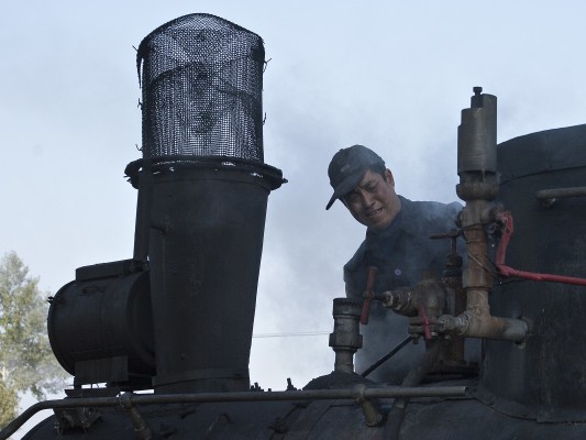 A worker of the Huanan Forestry Railway services 0-8-0 C2 steam locomotive 168 during a water stop in Xiahua on September 28, 2005.