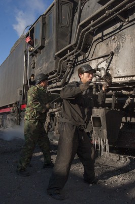 Jitong Railway workers clean the firebox of a QJ steam locomotive in Daban, Inner Mongolia, China, in November 2005.