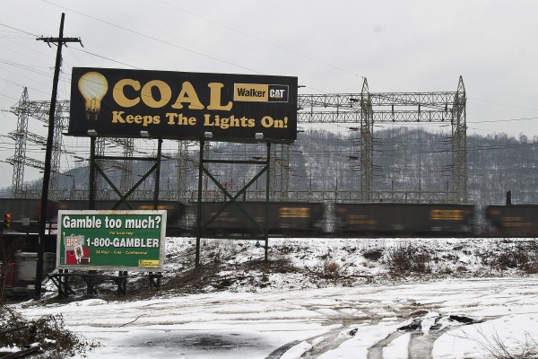 A Walker Cat billboard proclaims the electricity-generating capabilities of coal as a CSX coal train passes behind it on a dreary winter day in Cabin Creek, West Virginia.