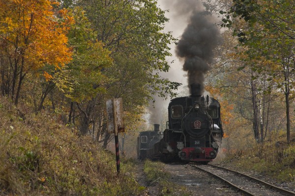 An eight-car loaded coal arrives at the summit of the Huanan Forestry Railway after the short but steep climb from Lixin on September 29, 2005. Locomotive 168 will take the train west to Huanan, while the helper on the rear will return to Lixin empty cars to the mines at Hongguang.