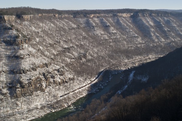 On a bright winter day in 2004, a westbound CSX empty coal train threads West Virginia's New River Gorge, seen from the former mining site of Kaymoor.