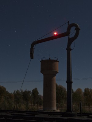 Moonlight illuminates the water tower on the Jitong Railway at Gulumanhan, Inner Mongolia, China, on an October night in 2005. Gulumanhan was a water stop for all westbound train.