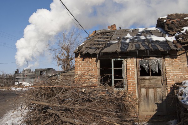 A coal train passes a dilapidated brick house in the village Tuoyaozi on the Huanan narrow gauge railway on November 27, 2005.