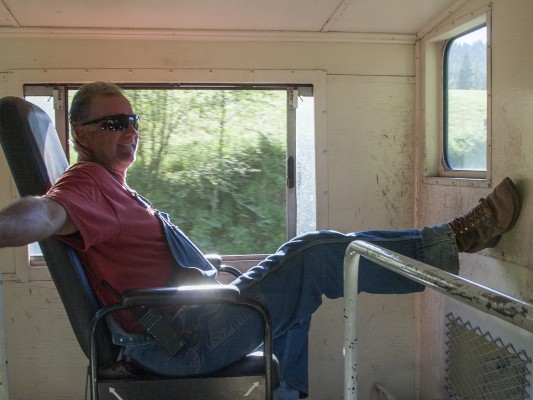 St. Maries River Railroad conductor Pat Hough oversees the progress of the inbound Clarkia Logger from the cupola of his caboose as the train nears St. Maries at the end of a long day in July 2005.