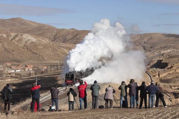 Railroad photographers flock to a steam-powered passenger special crossing Inner Mongolia's Jingpeng Pass on the Jitong Railway in November 2005.