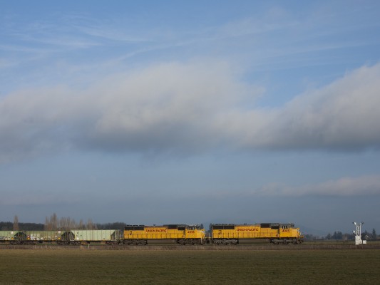 Two Union Pacific Railroad SD70M diesel locomotives pull a ballast train south through the Willamette Valley near Tangent, Oregon, on February 7, 2009.