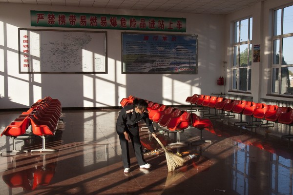 A Jitong Railway worker sweeps the station following the departure of the morning local passenger train.