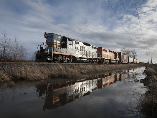 Portland and Western GP9 locomotive 1801 leads the American Turn north between Junction City and Albany, Oregon, on December 21, 2009. The locomotive's colors were inspired by the "black widow" paint of the Southern Pacific Railroad.
