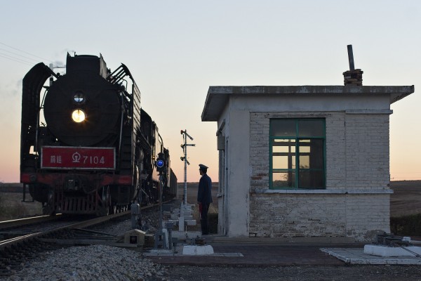 Just after sunset in October 2005, an eastbound Jitong Railway freight train pulls into Gulumanhan.