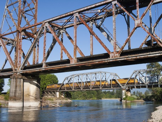 Four locomotives lead Union Pacific's Roseville to Portland Terminal freight train north over the Willamette River on the evening of July 30, 2008. The train is crossing the former Southern Pacific bridge, while the bridge in the foreground carries Portland and Western's former Oregon Electric Railroad line.