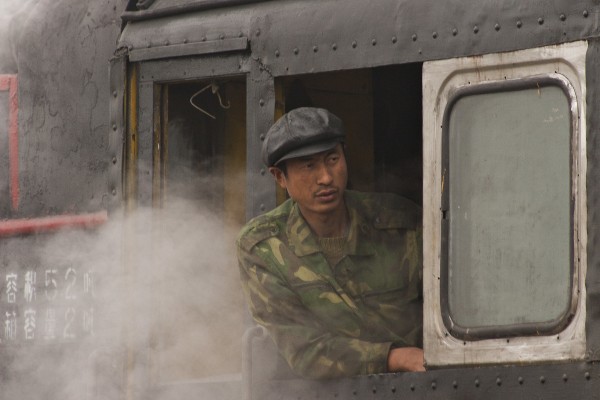In the village of Xiahua, an engineer on the Huanan Forestry Railway looks out from the cab of his narrow-gauge 0-8-0 C2 locomotive on the foggy morning of September 27, 2005.