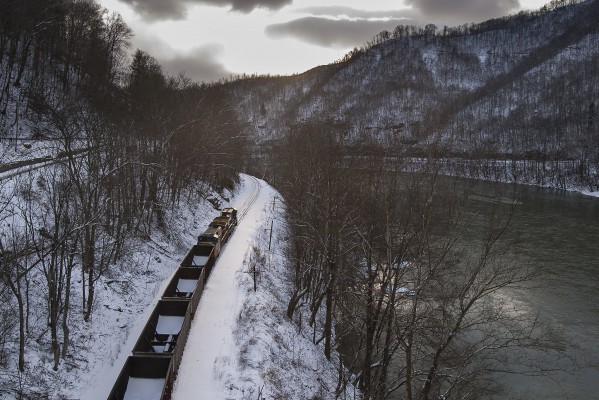 Silvery winter sunlight penetrates the clouds at Kanawha Falls, West Virginia, as a CSX empty coal train heads west down the Kanawha River.