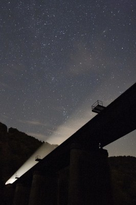 On a starry night along the West Virginia-Maryland border, a CSX freight train shines its headlights out of a tunnel and across a bridge over the Potomac River on the Magnolia Cutoff.